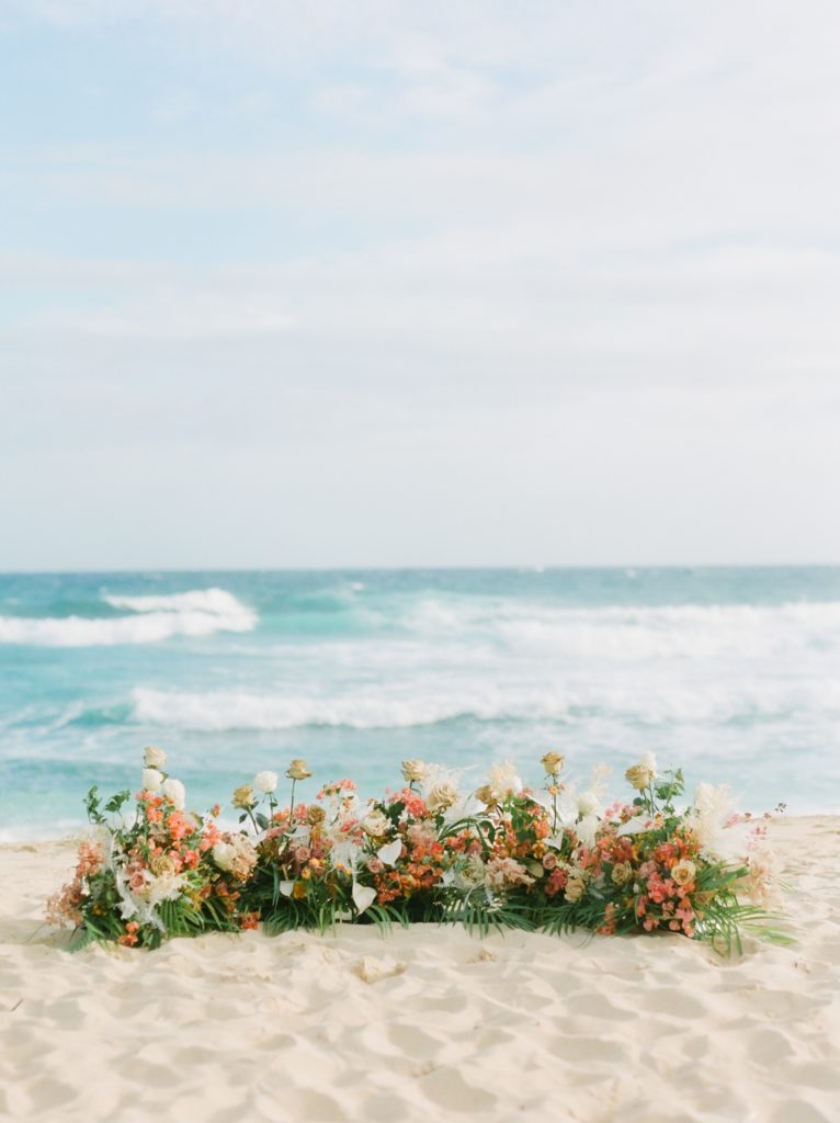 Hawaii beach ceremony wedding flowers